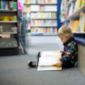 enfant qui lit un livre en librairie